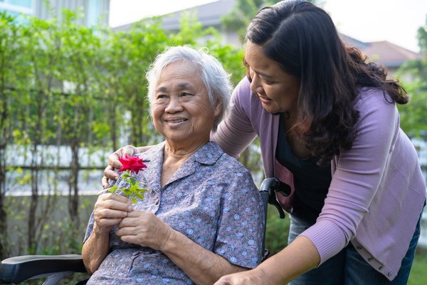 dementia-caregiver-helping-elderly-woman-wheelchair